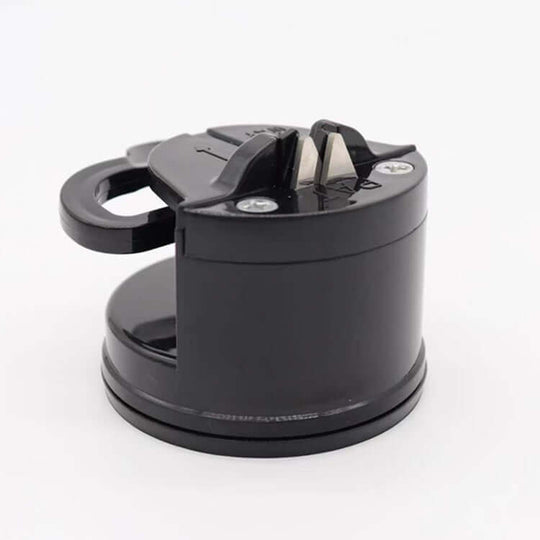 A black knife sharpener with a handle and suction base on a white background.